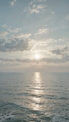 Obraz premium Sunset over calm sea with golden reflection on water