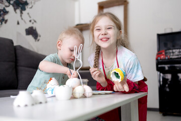 Naklejka premium A boy and a girl paint eggs for Easter.
