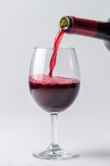 Red wine pouring into glass with bubbles and bottle