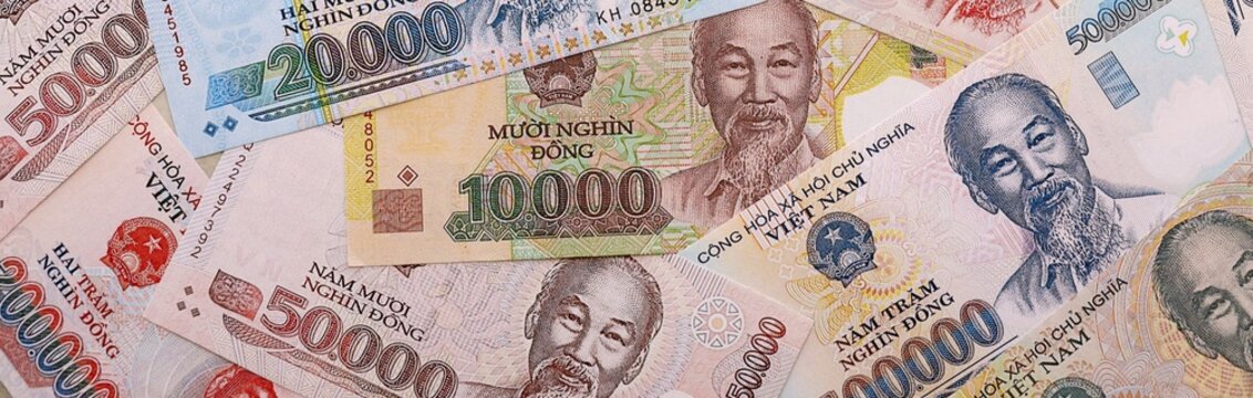 Vietnamese dong money bills pile on table. Vietnam banknotes of VND currency close up.