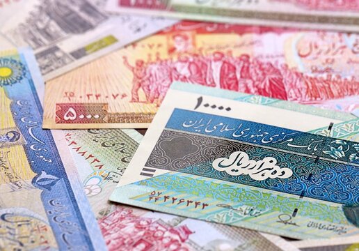 Iranian rial money bills pile on table. Iran banknotes of IRR currency close up.