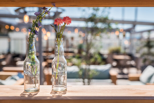 Interior design elements of old bottles containing flowers on a shelf in restaurant beach bar club