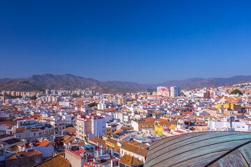 Fototapeta premium Detailed view of Malaga Cathedral green copper roof with city and mountains background