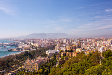 Obraz premium Malaga city skyline with historical architecture and Malaga Cathedral viewed from Gibralfaro hill in La Malagueta district area under a clear blue sky during a bright sunny day in Andalusia Spain.