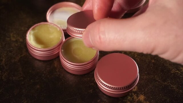 Artisan hand closing homemade organic lip balm tins