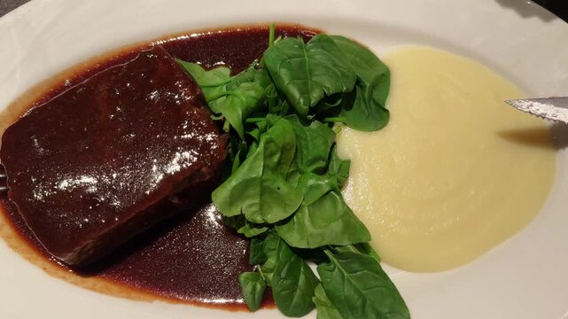 Oxtail with truffled Parmentier and a Montsant red wine sauce with with mashed potatoes and spinach. High quality 4k footage