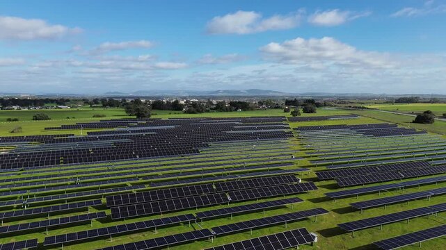A cinematic 4K aerial drone video filmed in a solar farm in the province of Cadiz Andalusia Spain. The drone flies forward while slowly ascending above solar panels with sheep grazing underneath