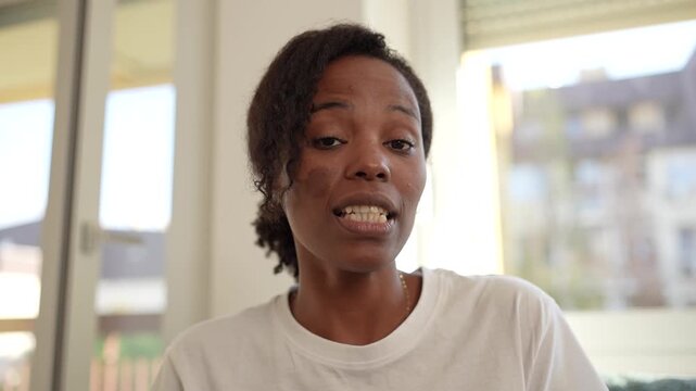 Woman speaking directly to camera indoors, expressing concern and sincerity. Emotional close-up capturing authentic communication, trust, and human connection in a modern lifestyle or interview settin