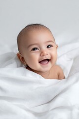 Adorable asian baby smiling cozy in white blanket