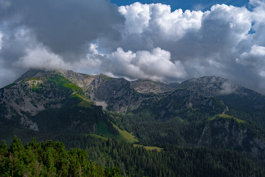 High mountain ridge wrapped in heavy clouds on a bright summer day