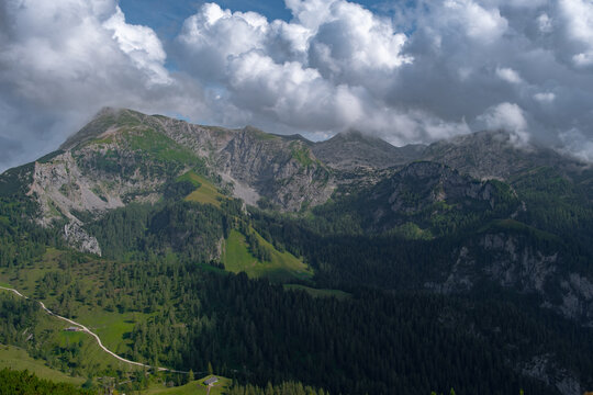 Scenic view of mountains with passing shadows under a bright cloudy sky