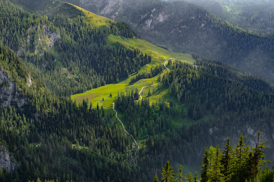 Aerial view of a path leading to mountain shepherds' huts on a bright sunny day