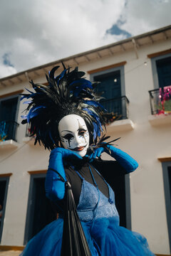 Figura de querubim em alegoria de rua durante o Carnaval de Tiradentes, com sombrinhas coloridas de frevo ao fundo, Minas Gerais.