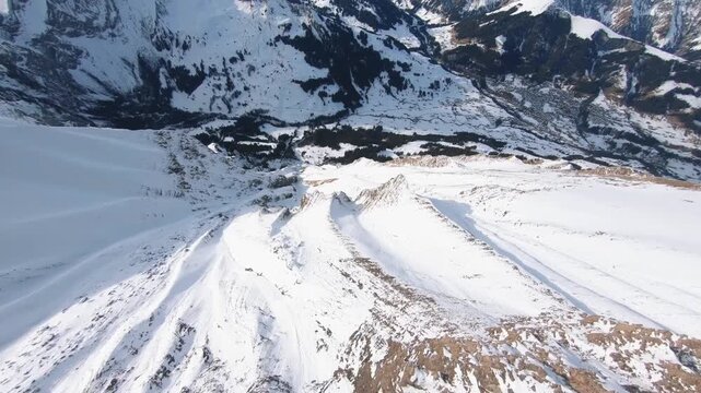Thrilling Aerial Dive Down Massive Snowy Mountain Fac into Valley