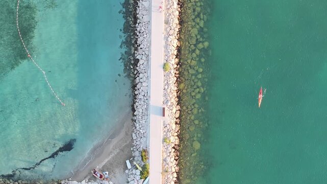 Kayaker paddling slowly along Omis coastline in Dalmatia, Croatia.