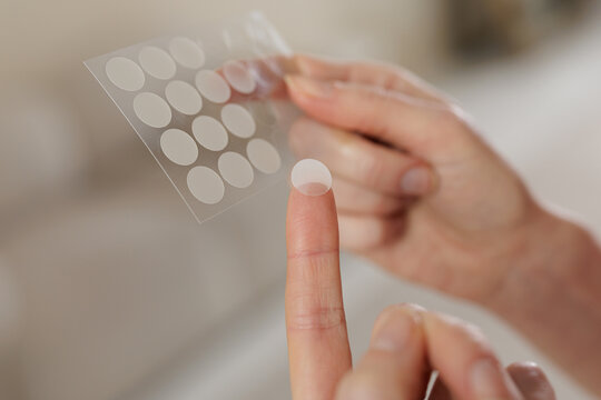 Hydrocolloid Acne Patch On Finger From Skincare Sticker Sheet Closeup