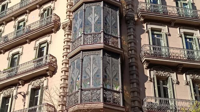 Camera tilting up a beautiful modernizm style building with intricate balconies and stained glass