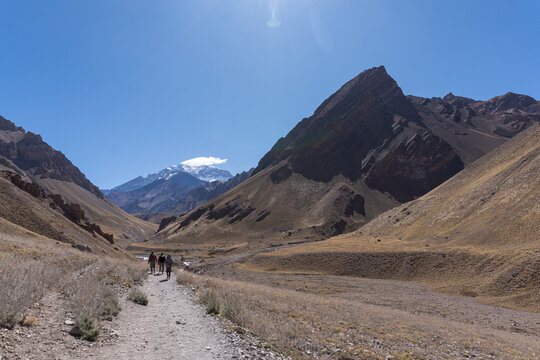 Gente caminando entre monta&ntilde;as hacia el cerro Aconcagua d&iacute;a despejado senderismo