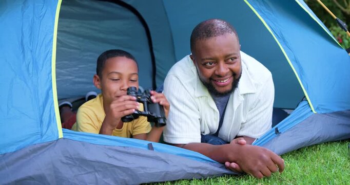 African American dad and child pointing, dad leading child into grabbing binoculars at blue tent