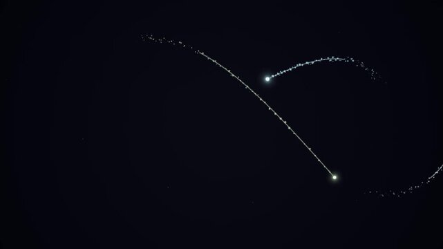 Two bright meteors streak across the dark night sky, leaving glowing trails behind them, a celestial spectacle.