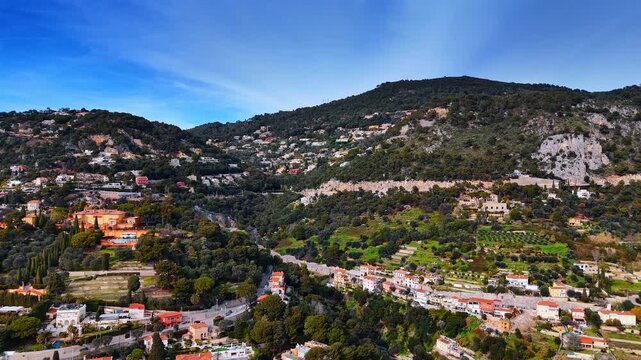 Scenic view of luxurious Nice, France scattered on the green mountains. Drone flight over the picturesque cityscape on sunny day.