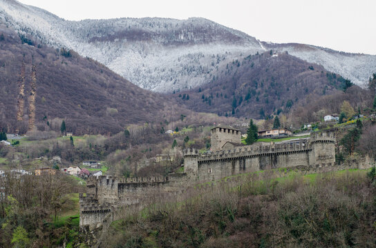 BELLINZONA, SWITZERLAND &ndash; MARCH 23, 2014: Montebello Castle with surrounding defensive walls and snow-covered mountains in the background