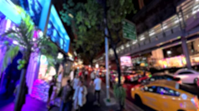 BANGKOK, THAILAND - NOV 2025 : Walking view of Sukhumvit street filled with neon lights of the nightlife entertainment district and urban traffic.