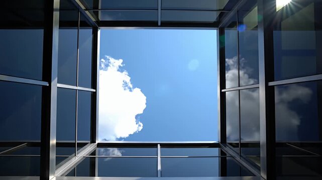View of blue sky through modern glass and metal ceiling