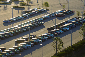 Aerial view of dealership parking lot with many brand new cars for sale. Development of american...