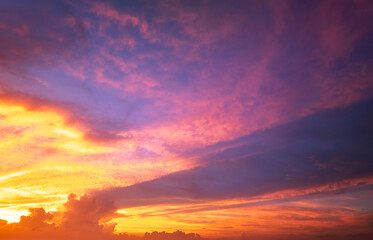 Fototapeta premium Bright sunset with setting sun behind vivid orange and yellow clouds