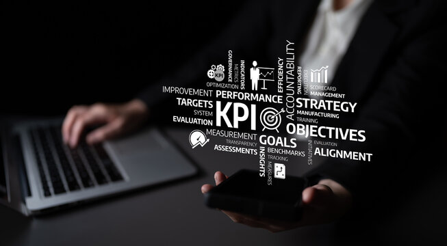 This image depicts a business professional holding a smartphone while interacting with modern performance management concepts, emphasizing KPIs and strategic goals. Tessel