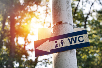 Arrow with Wc sign, outdoors at the park