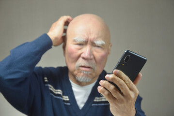 スマートフォンを操作する老人