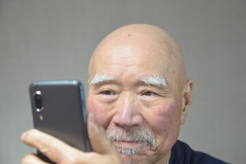 スマートフォンを操作する老人