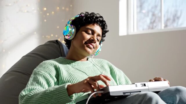 Young woman relaxes listening to music with headphones indoors