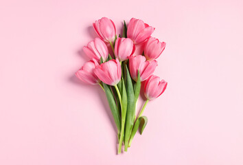 Fototapeta premium Bouquet of tulips on pink background, top view