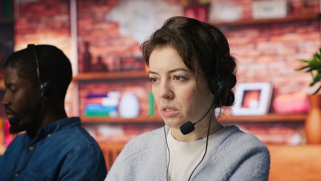 Customer support workers assisting clients to meet outbound call quotas and sales targets. Call center agents contacting prospects to inform them about new products, camera A