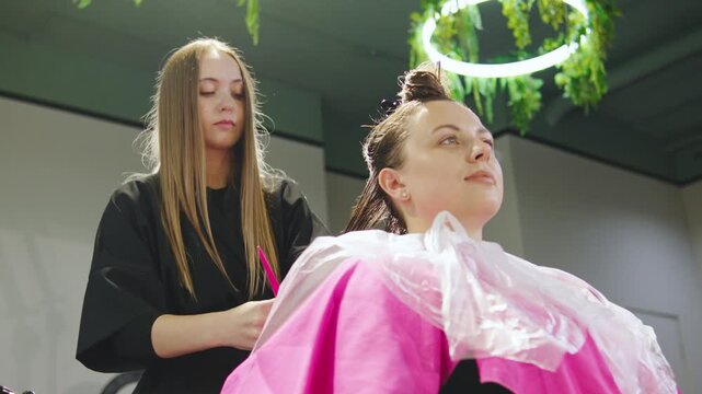 Stylist working on hair of client in a modern salon during a busy afternoon
