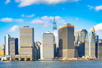 Obraz premium Panoramic view of Lower Manhattan skyline in New York City with One World Trade Center and modern skyscrapers seen from the East River on a sunny day