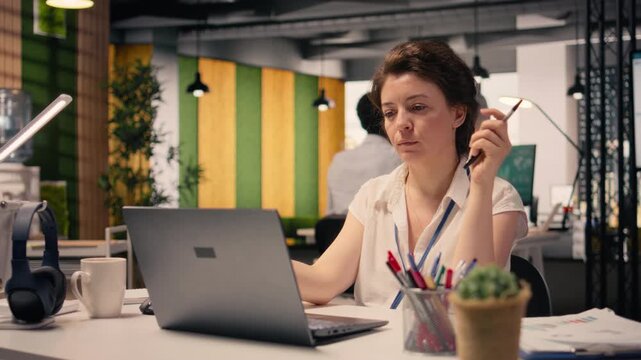 Professional woman concentrating and pondering vision in modern office, considering ideas and strategy while reviewing forecasting reports and insights. Reflection and decision making.