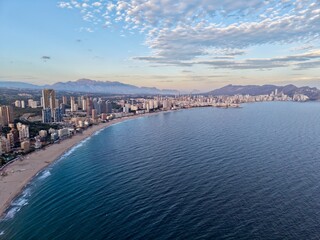 Fototapeta premium coastline sea panorama, vast coastal waters and city edge form picturesque curve under gentle morning light
