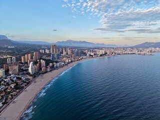 Obraz premium picturesque shoreline featuring highrise structures and generous stretch of golden sands under serene sky
