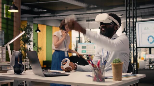African American man wearing VR headset goggles in a modern office, interacting with computer-generated images and 3D simulation. Virtual reality and artificial intelligence for business analytics.