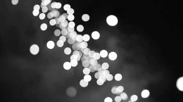 Abstract black and white bokeh light display with bright orbs and a diagonal divide creating a simple background