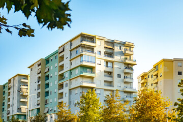 Contemporary Modern residential buildings facade with balconies under clear blue sky, community with lush greenery, modern architecture_ well-maintained landscape, apartment buildings city lifestyle © kittyfly