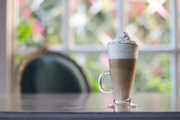 Delicious Mocha coffee drink with whipped cream in glass mug on wooden table