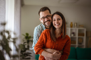 Fototapeta premium Happy couple embracing at home showing togetherness