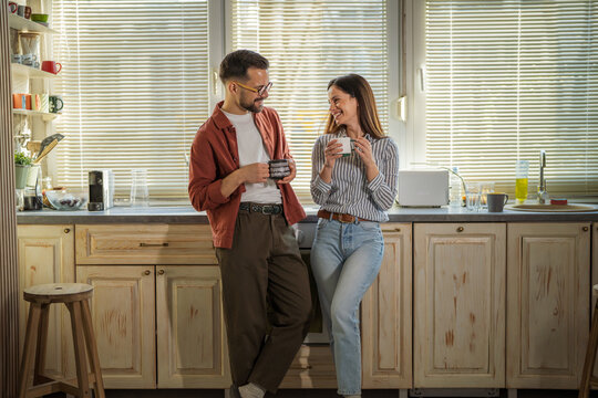 Couple drinking morning coffee in bright kitchen