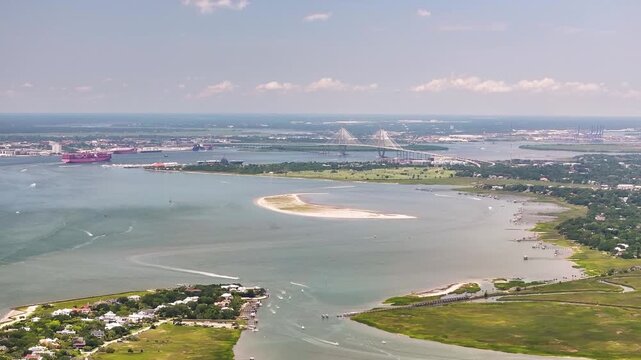 Panoramic aerial view of Arthur Ravenel Jr. Bridge and container ship in Charleston, South Carolina lowcountry landscape showing cityscape, waterway, and homes from Sullivan's Island - 4K Drone