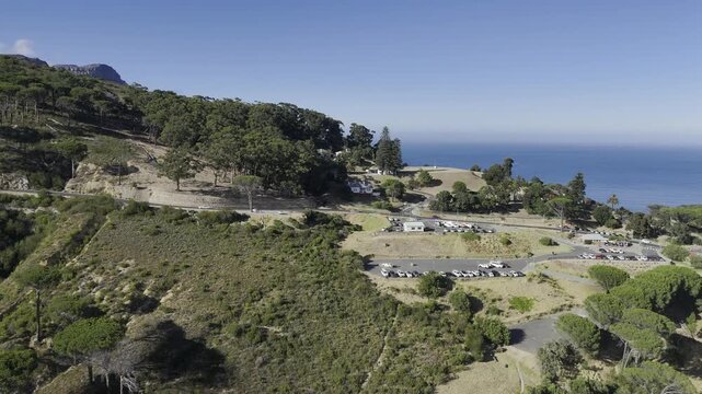 Drone flies to the right and follows the M62 toward Camp's Bay in the late morning in Cape Town, South Africa